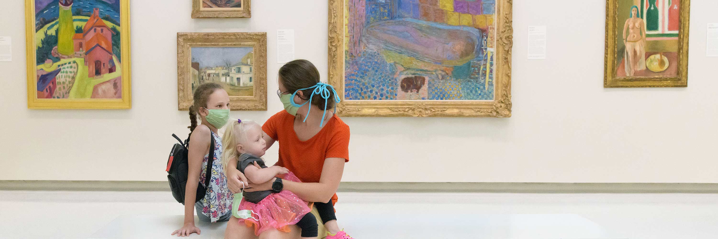Mother and young daughters in masks at the Carnegie Museum of Art
