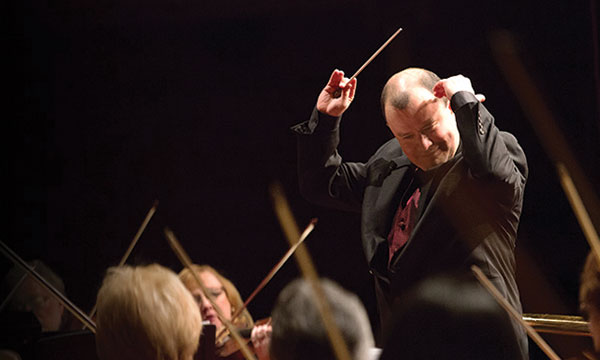 Conductor leading musicians of the Edgewood Symphony Orchestra in a concert.