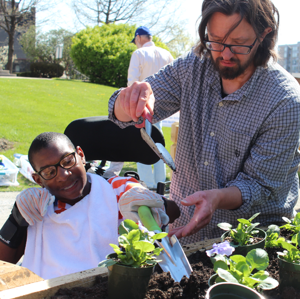 Boy in a wheelchair gardens with Western PA Conservancy.