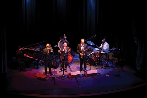 Photo from a distance of a jazz ensemble performing on a stage