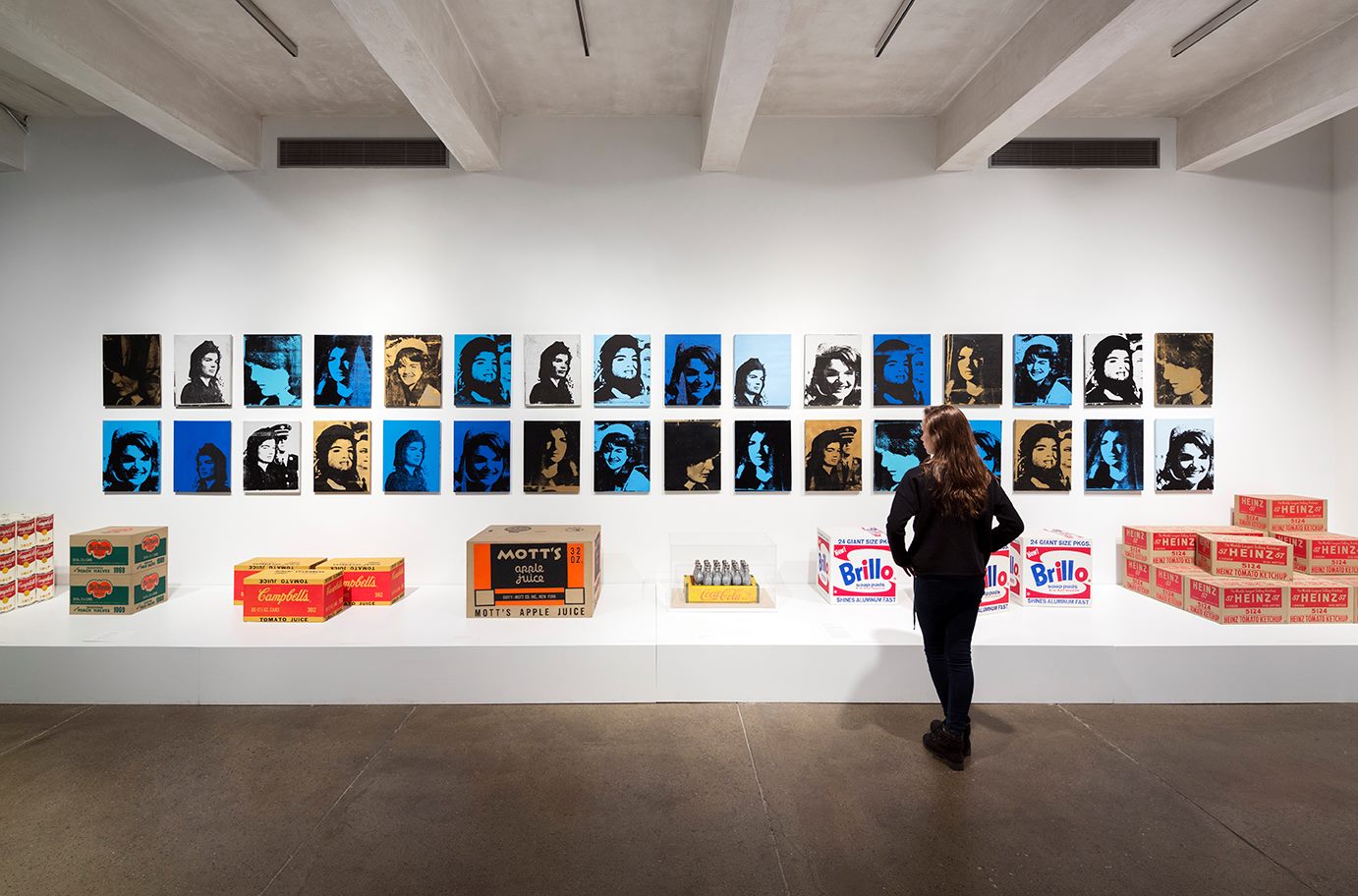Woman standing in front of Warhol paintings