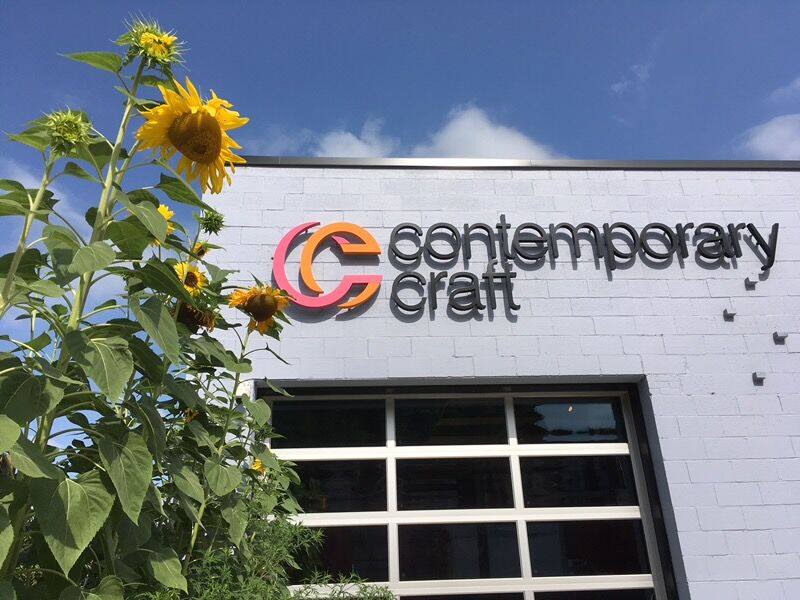 Exterior shot of Contemporary Craft's new building with sunflowers growing on the side.