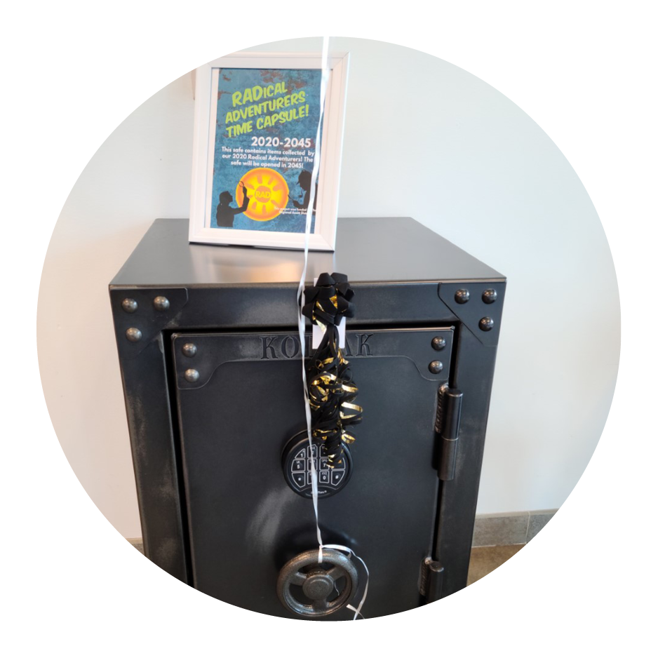 Large, vintage black safe with "RADical Adventures" time capsule sign on top.