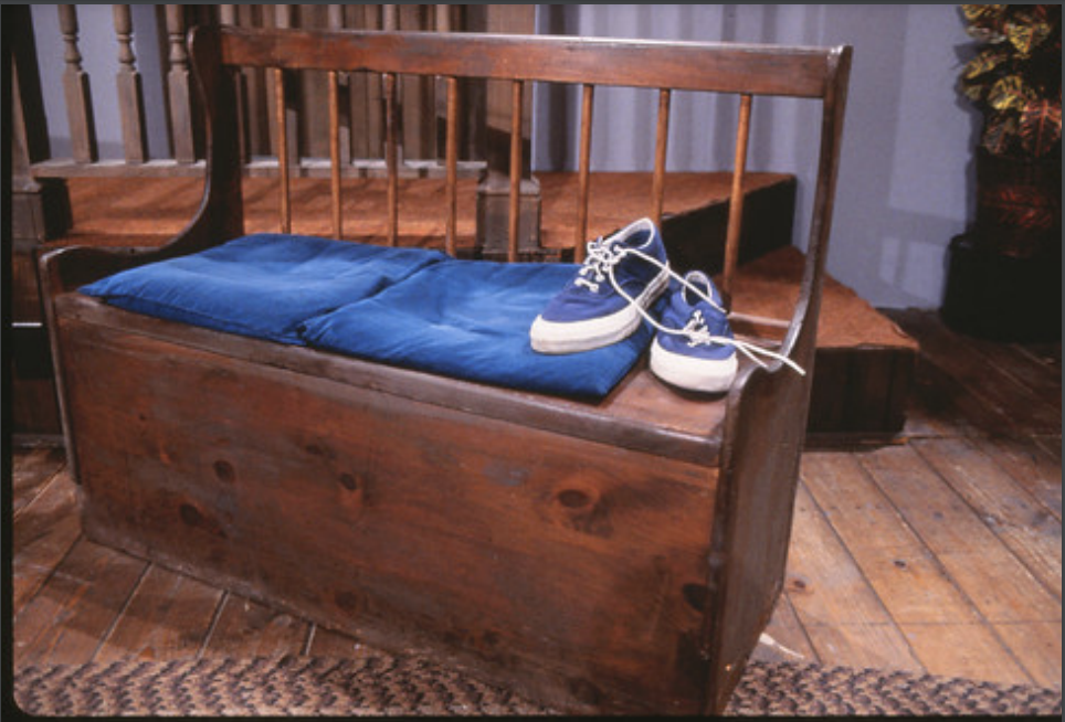 Photo of Mr. Rogers' blue sneakers on the wooden bench of his set.