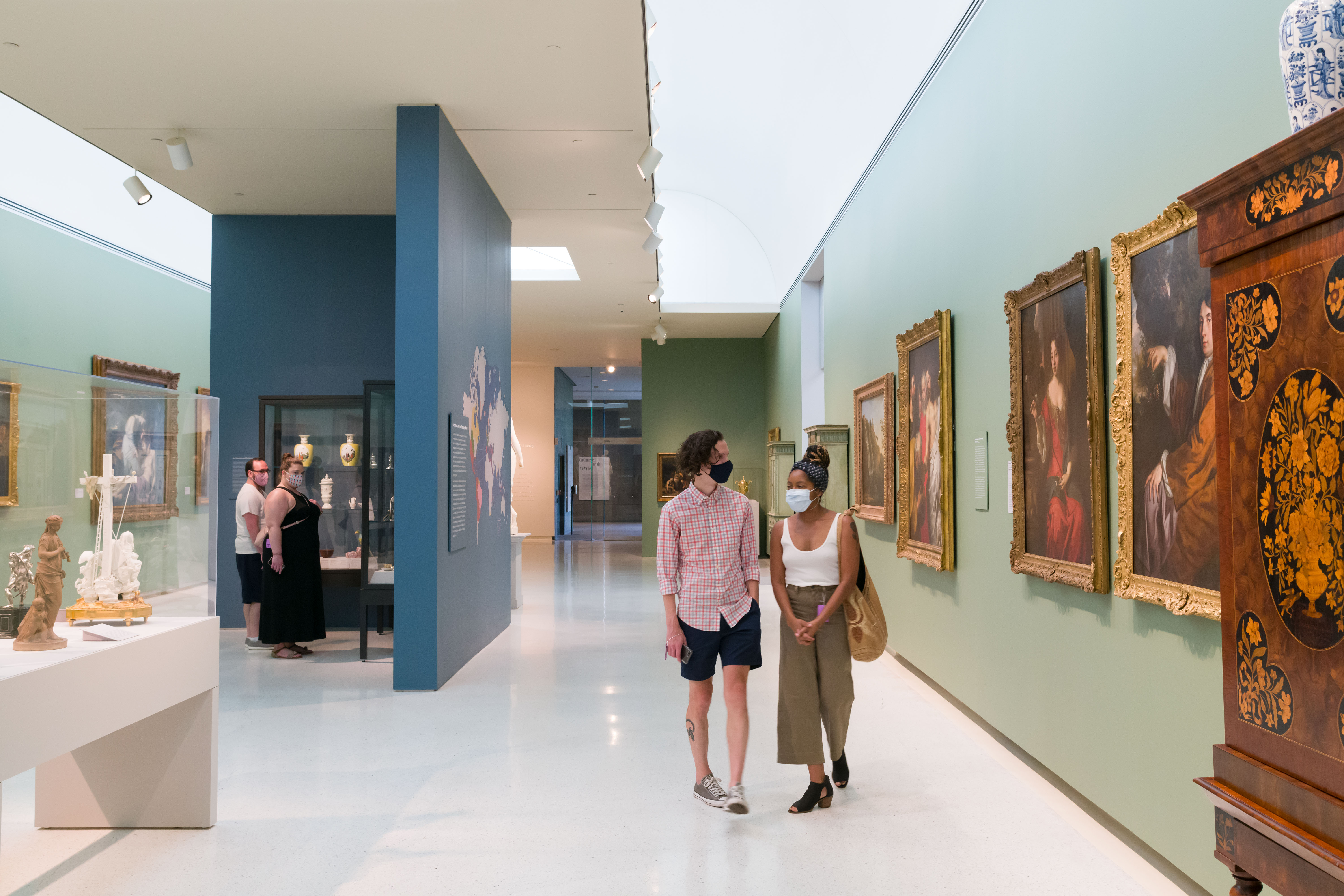 People in masks browsing an art exhibit at Carnegie Museum of Fine Art. Photo by Bryan Conley.