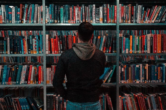Man in stacks of library books