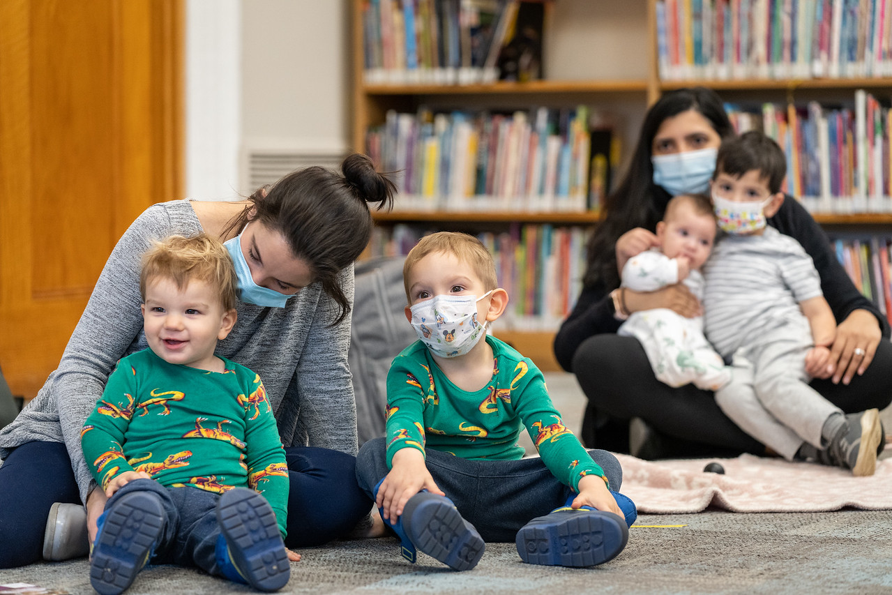 Two women and four children participate in story time at a local library