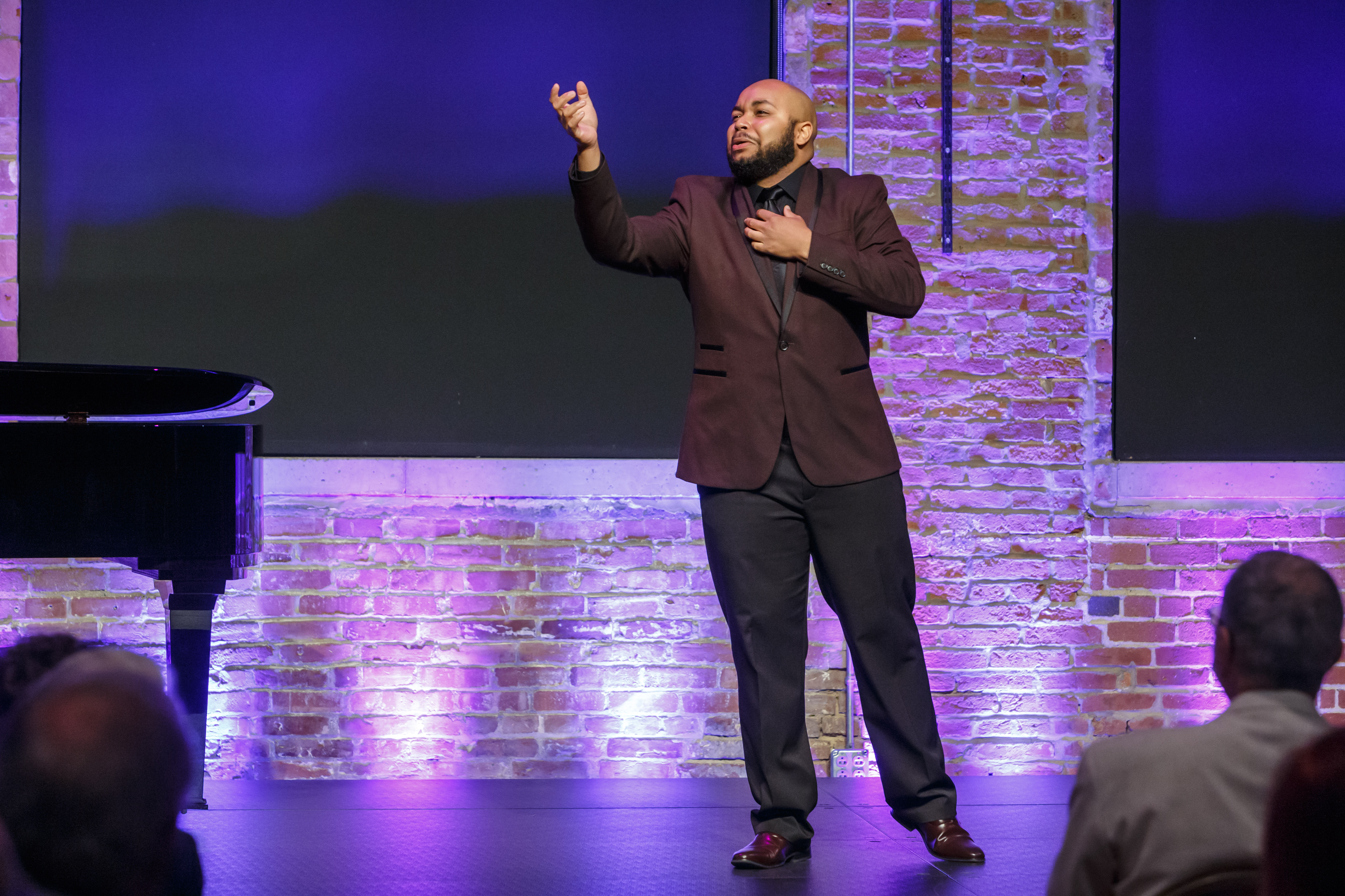 Image of an African American man singing opera on a stage