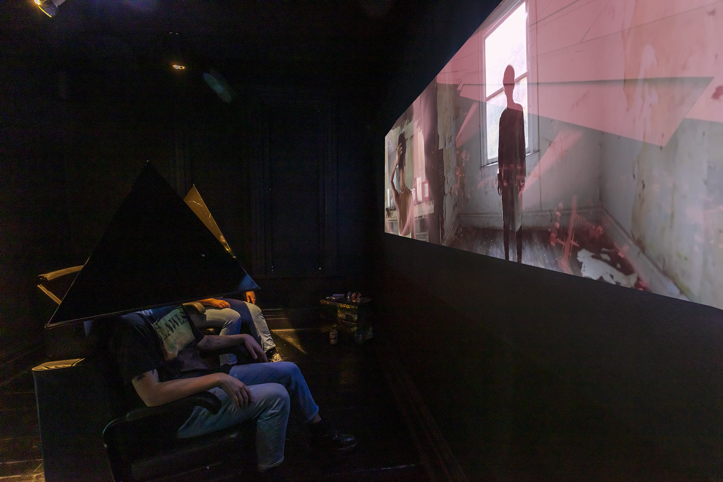 Person sitting in front of screen in exhibition