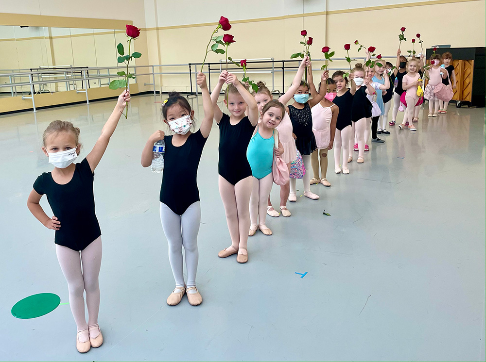 Ballet girls in a line holding roses