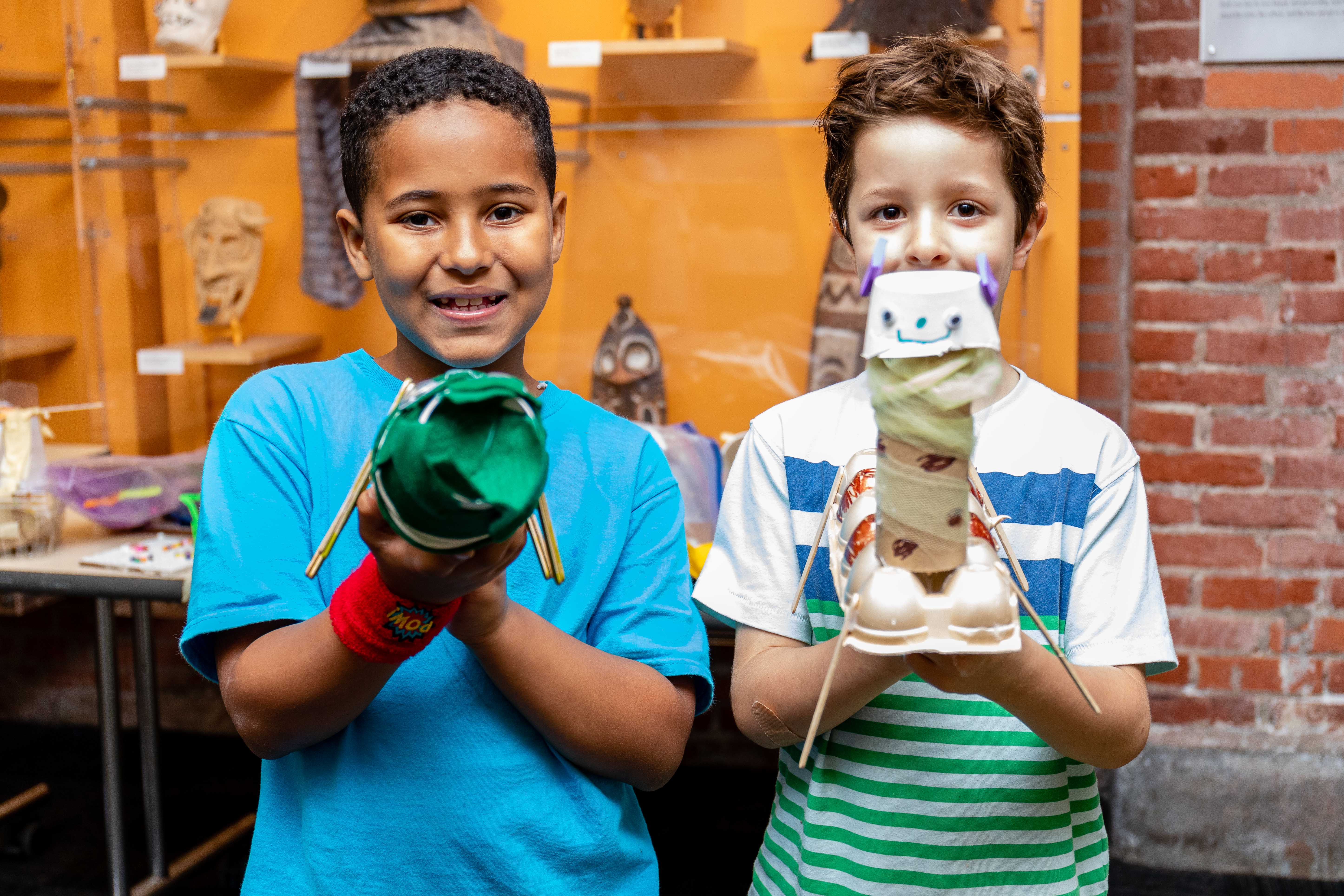 Two boys holding up their artwork at the Children's Museum of Pittsburgh