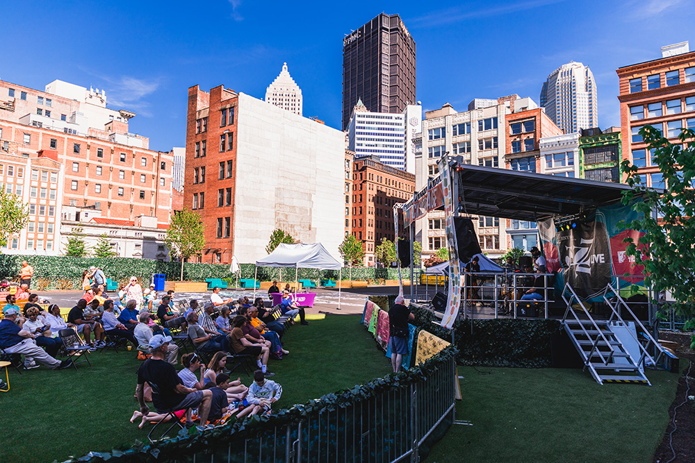 People sitting in front of an outdoor stage in Downtown Pittsburgh