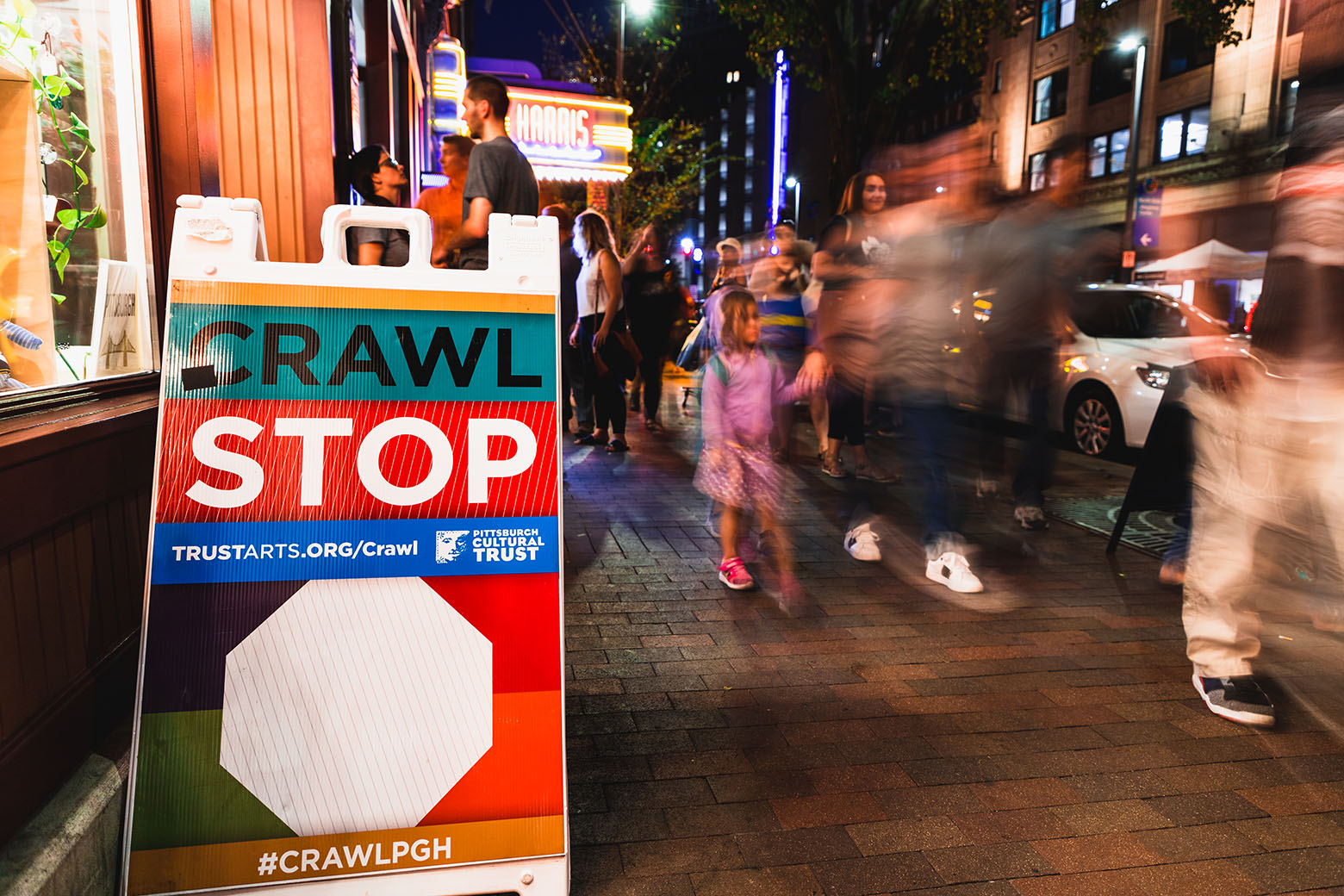 People walking through the streets at night in Pittsburgh's Cultural District