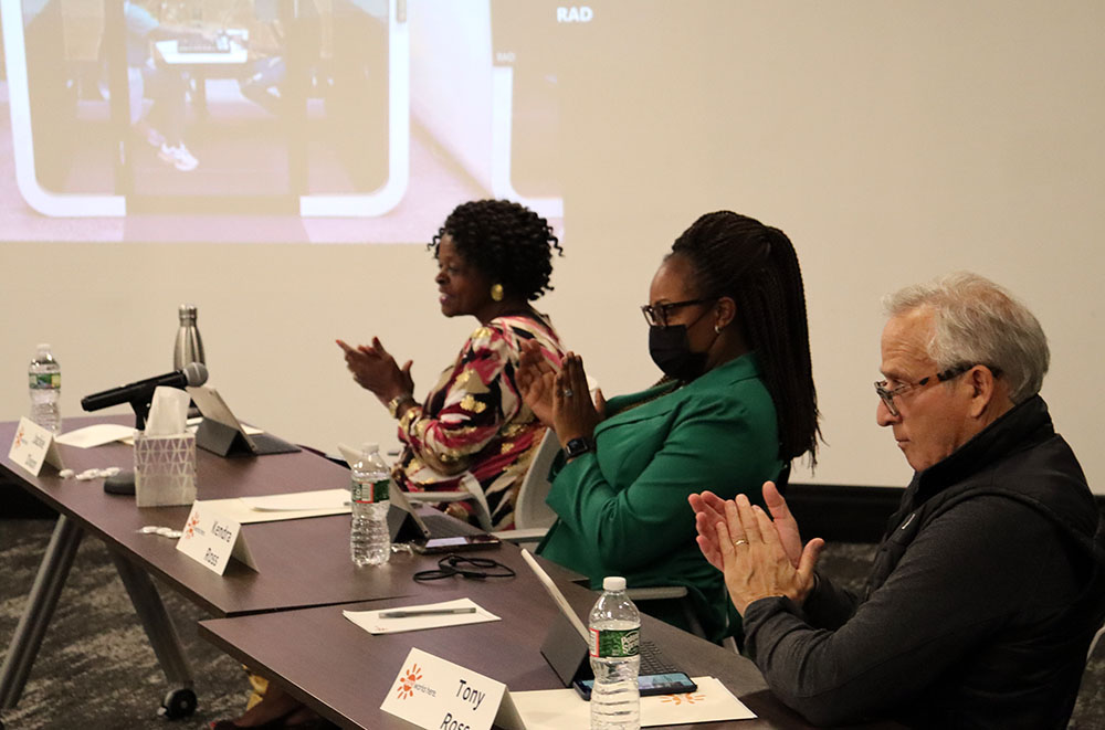 RAD board members Jackie Dixon, Dr. Kendra Ross and Tony Ross seen applauding while sitting at a table
