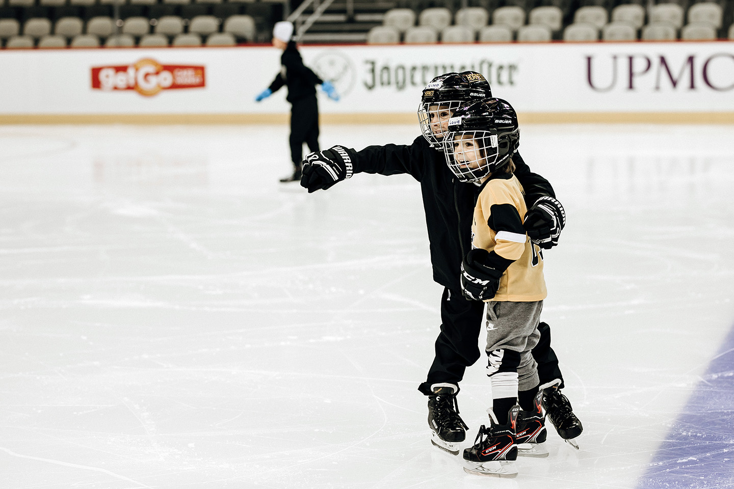 Two brothers holding one another on the ice at PPG Paints Arena