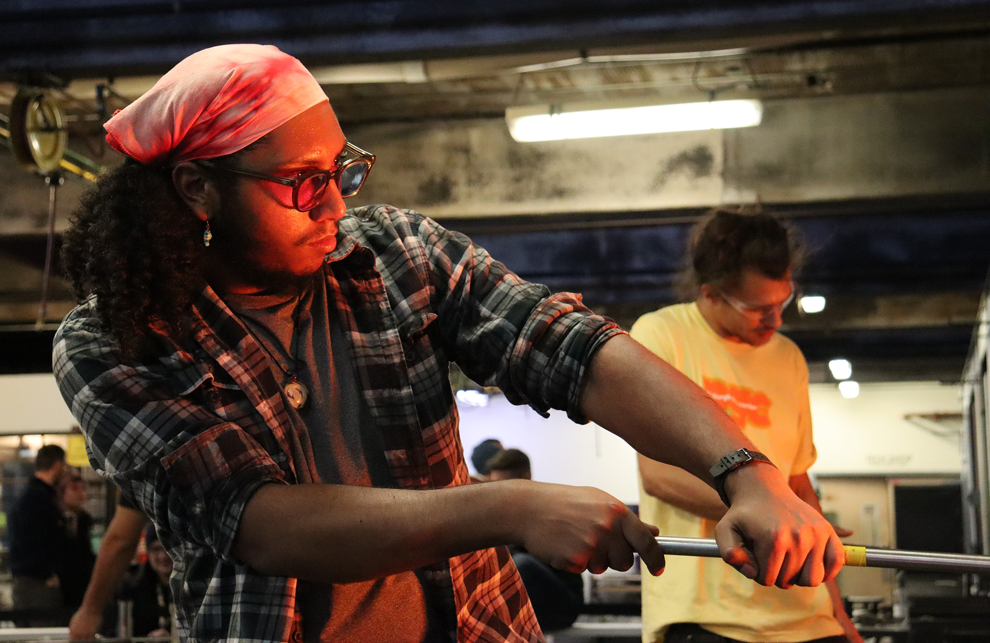 Two glass artists working in front of a hot oven