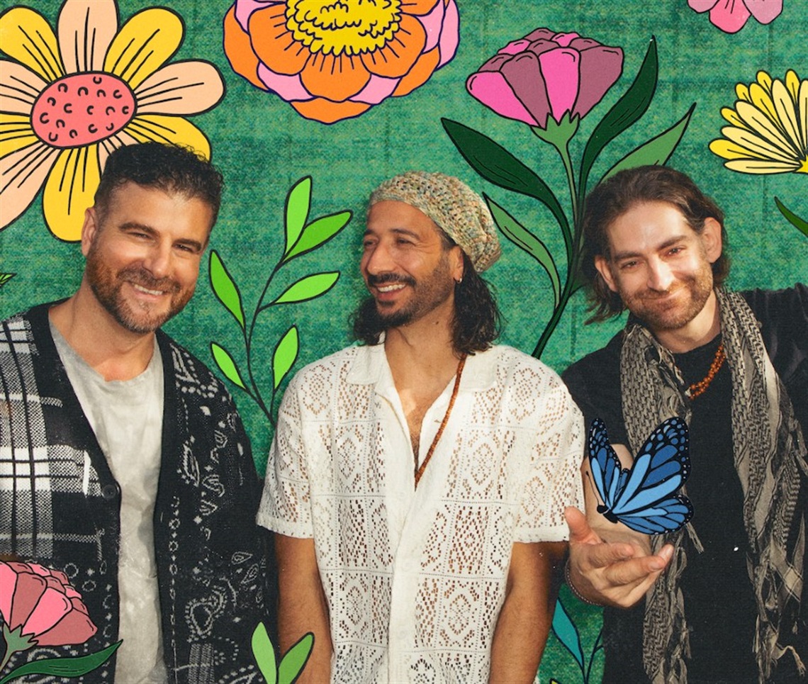 Photograph of three members of MAGIC! in front of a colorful wall