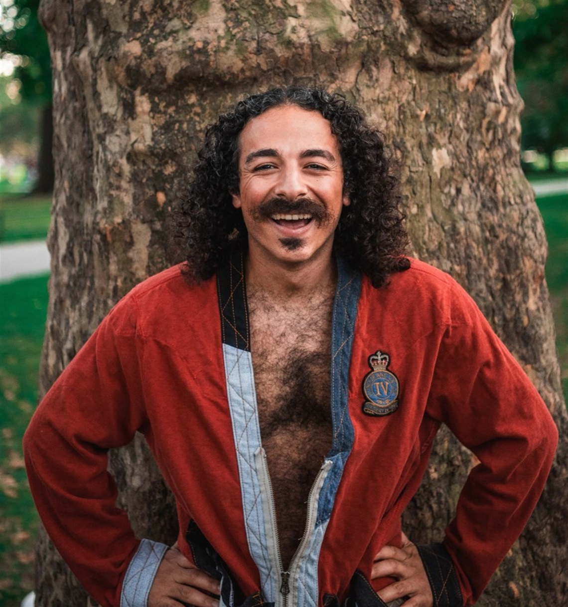 Photograph of Anees standing in front of a tree