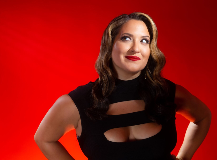 Photograph of Nicole Zuraitis in front of a red background