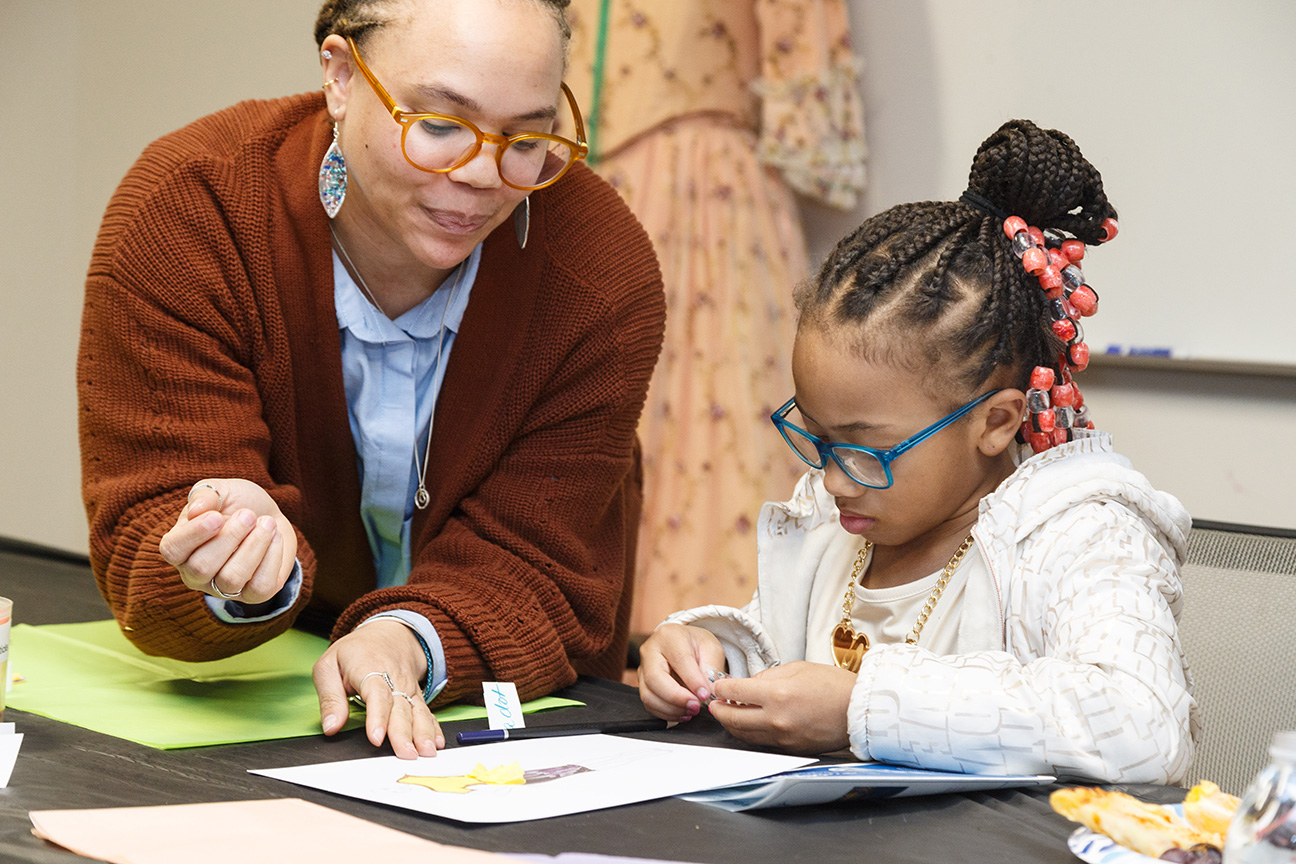 Photograph of a teacher helping a student at a desk
