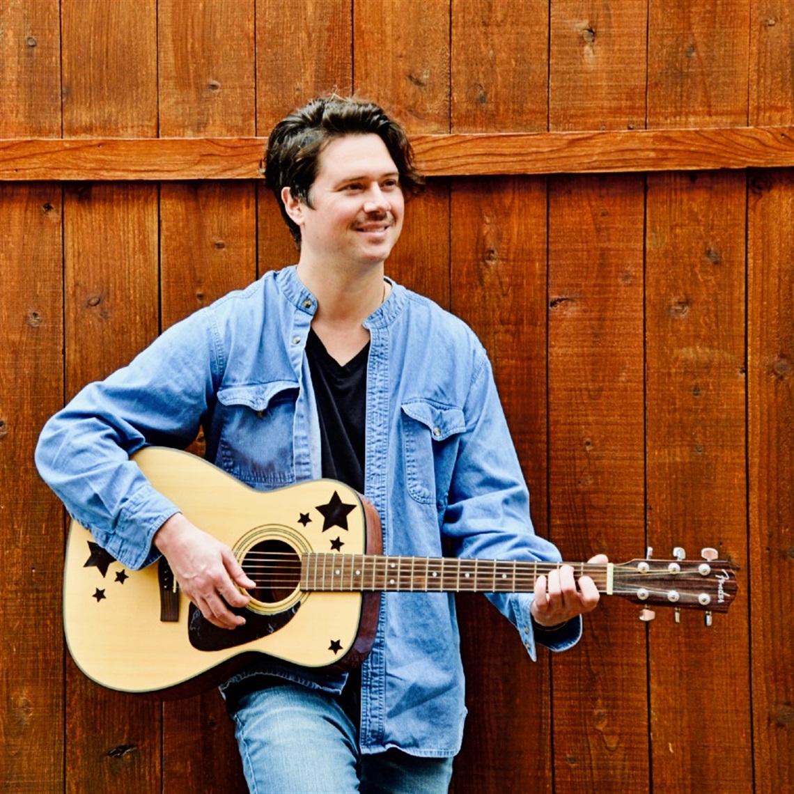 Photograph of Reliable Child with an acoustic guitar