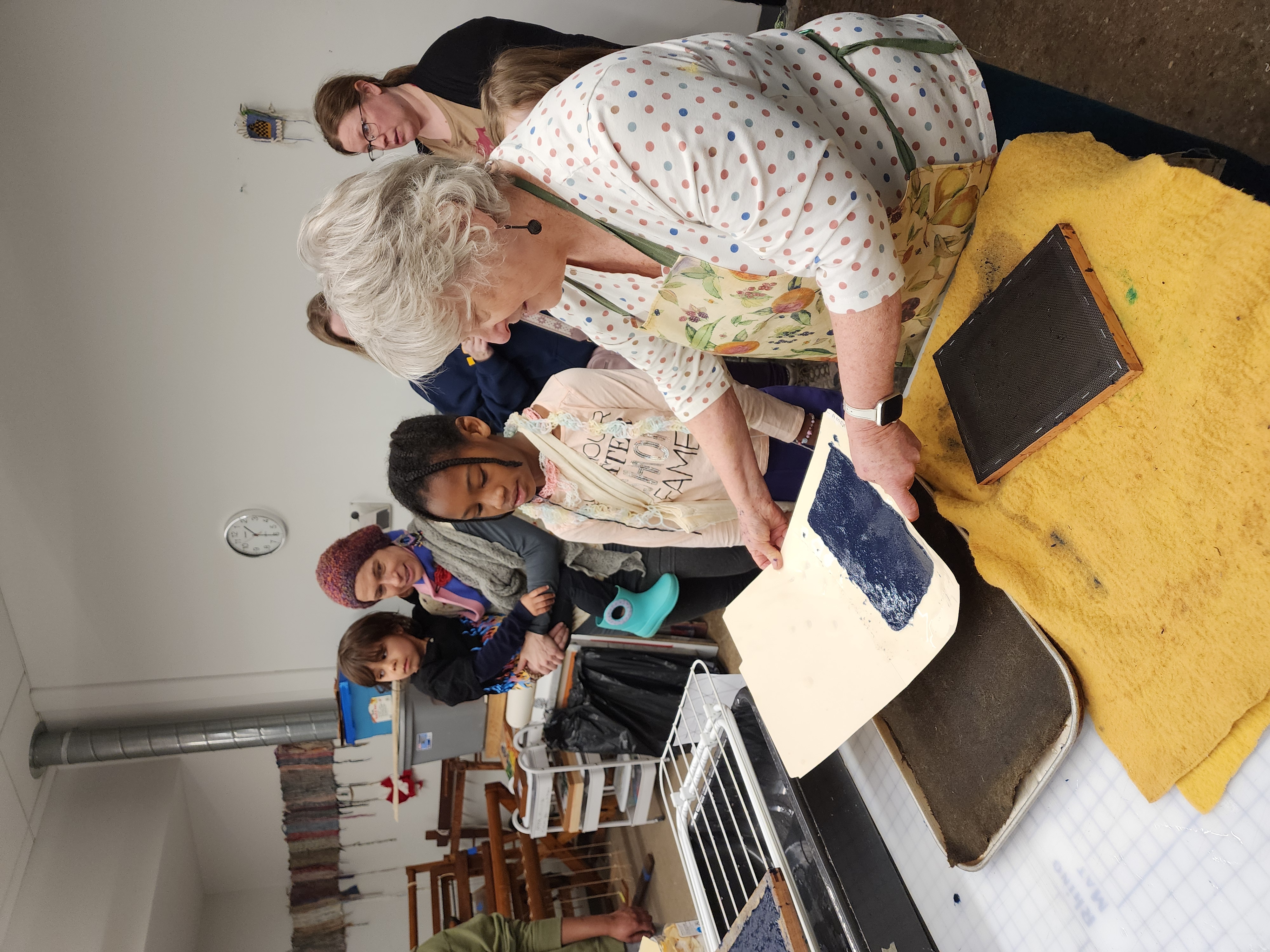 A woman showing a tour group a demonstration of materials
