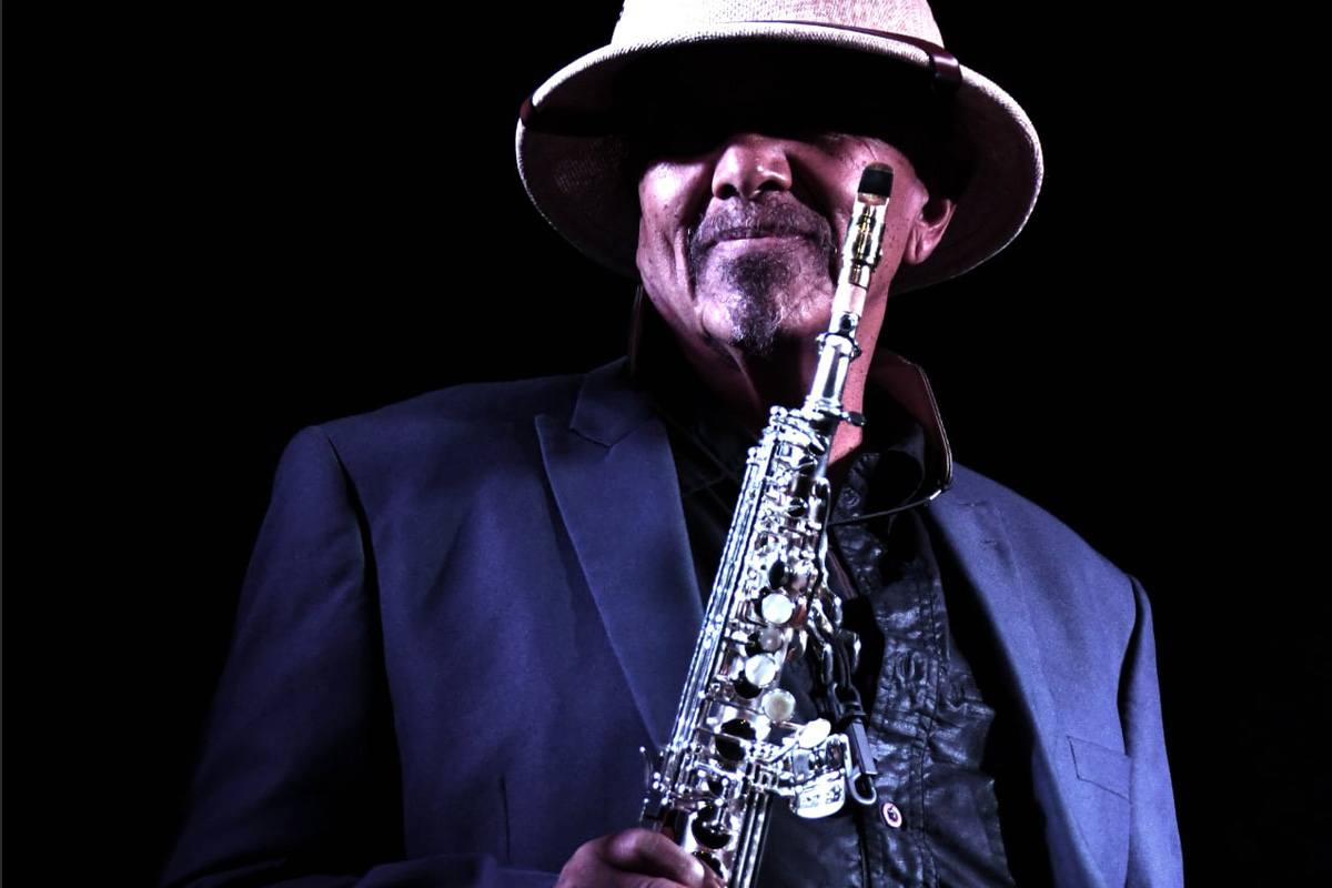 Photograph of Kenny Blake wearing a Panama hat