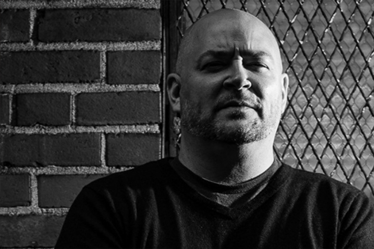 Black and white photograph of David Throckmorton in front of a fence