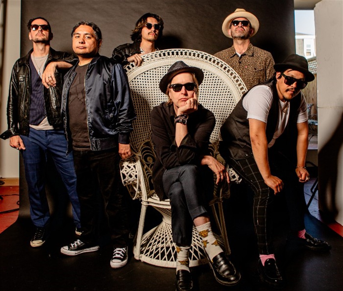 Six members of Chuck Prophet & His Cumbia Shoes, mostly in sunglasses and posing in a studio