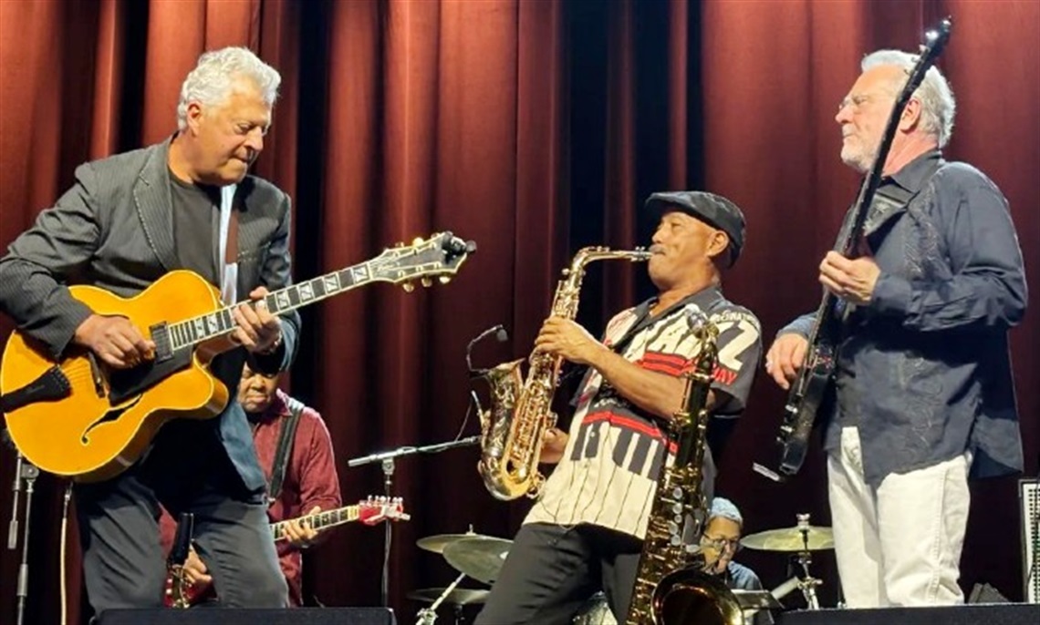 Members of BPM: Brian Bromberg, Paul Brown, Michael Paulo playing guitars and a saxophone on stage