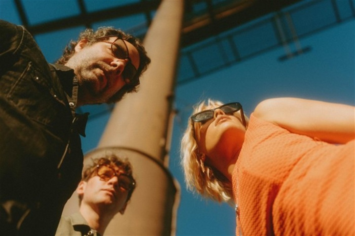 Stylized portrait of The Vindys, taking from below while the three band members are wearing sunglasses