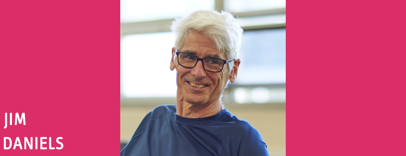 Photo of Jim Daniels, a middle-aged white man with white hair, glasses and a blue t-shirt