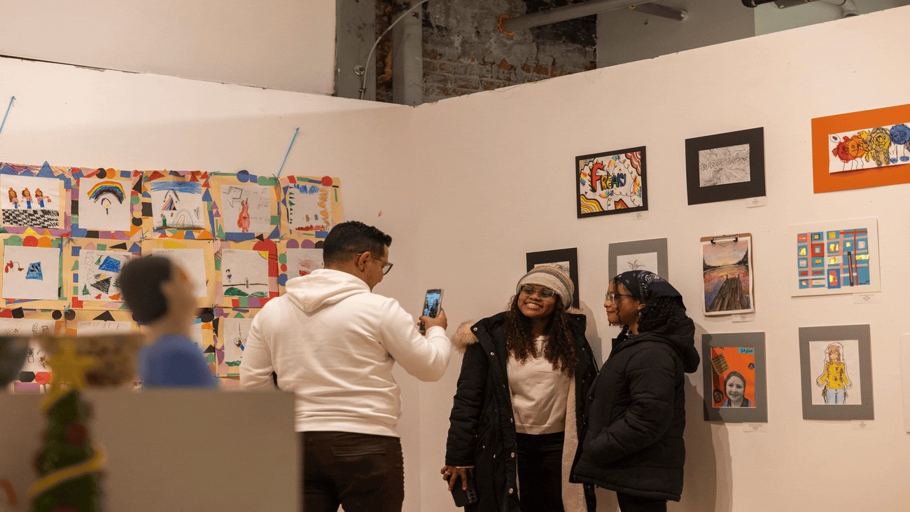 People standing in front of artwork getting their picture taken